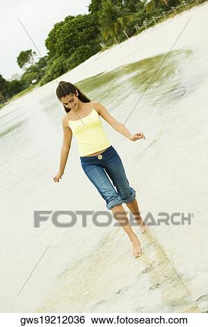 Girl wading in water on the beach View Large Photo Image Stock Photograph - Girl wading in water on the beach. Fotosearch
