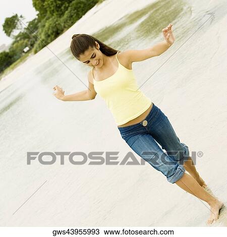 Stock Image - Girl walking on the beach. Fotosearch