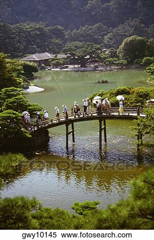Group of people walking on a bridge, Ritsurin Garden, Takamatsu, Shikoku, Japan View Large Photo Image Stock Photography - Group of people walking on a bridge, Ritsurin Garden, Takamatsu, Shikoku, Japan. Fotosearch