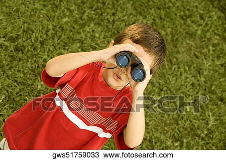 High angle view of a boy looking through a pair of binoculars View Large Photo Image Stock Image - High angle view of a boy looking through a pair of binoculars. Fotosearch
