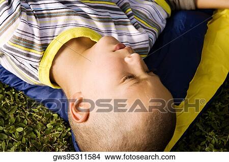 High angle view of a boy lying on a sleeping bag View Large Photo Image Picture - High angle view of a boy lying on a sleeping bag. Fotosearch