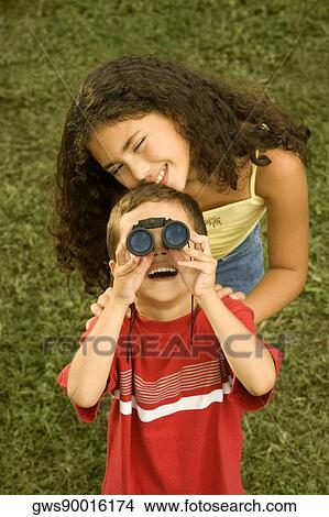 High angle view of a brother and his sister looking through a pair of binoculars View Large Photo Image Picture - High angle view of a brother and his sister looking through a pair of binoculars. Fotosearch