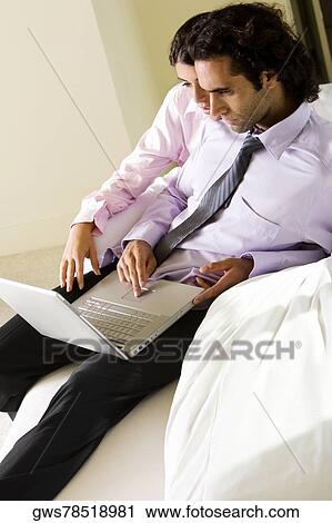 High angle view of a businessman and a businesswoman using a laptop View Large Photo Image Stock Image - High angle view of a businessman and a businesswoman using a laptop. Fotosearch