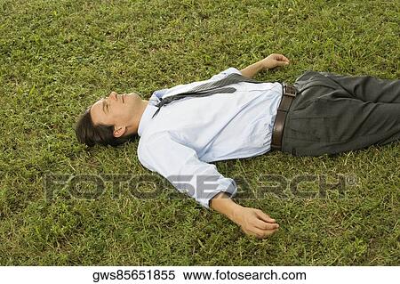 High angle view of a businessman lying on the grass View Large Photo Image Stock Photography - High angle view of a businessman lying on the grass. Fotosearch