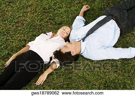 High angle view of a businesswoman and a businessman lying on the grass View Large Photo Image Stock Image - High angle view of a businesswoman and a businessman lying on the grass. Fotosearch