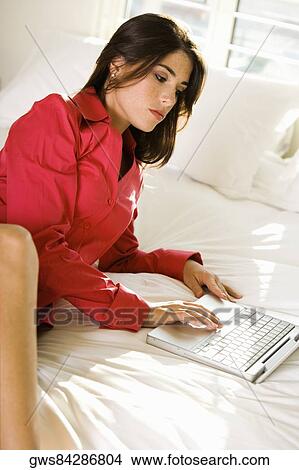 High angle view of a businesswoman using a laptop on the bed View Large Photo Image Picture - High angle view of a businesswoman using a laptop on the bed. Fotosearch