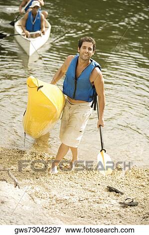 High angle view of a mid adult man holding a canoe View Large Photo Image Stock Photo - High angle view of a mid adult man holding a canoe. Fotosearch