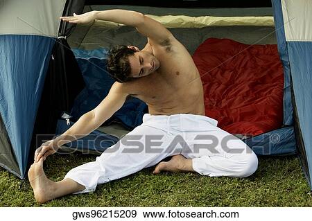 High angle view of a mid adult man exercising in front of a tent View Large Photo Image Stock Photo - High angle view of a mid adult man exercising in front of a tent. Fotosearch