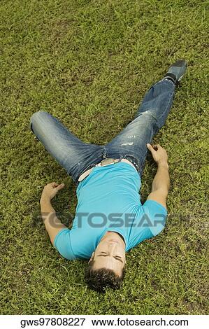 High angle view of a mid adult man lying on the grass View Large Photo Image Stock Photo - High angle view of a mid adult man lying on the grass. Fotosearch