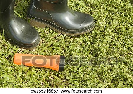 High angle view of a pair of boots with a flashlight on the grass View Large Photo Image Stock Photo - High angle view of a pair of boots with a flashlight on the grass. Fotosearch