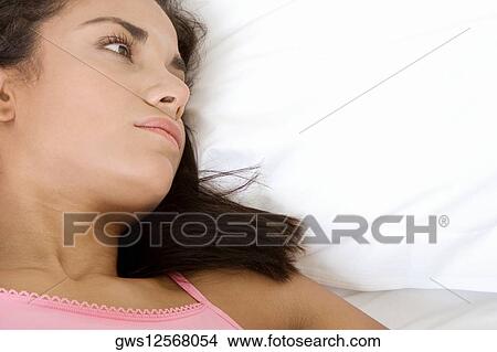 High angle view of a young woman lying on the bed View Large Photo Image Picture - High angle view of a young woman lying on the bed. Fotosearch