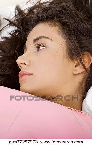 High angle view of a young woman thinking View Large Photo Image Stock Image - High angle view of a young woman thinking. Fotosearch