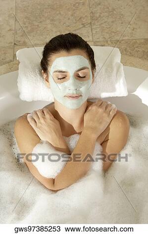 High angle view of a young woman wearing a facial mask in a bathtub View Large Photo Image Stock Image - High angle view of a young woman wearing a facial mask in a bathtub. Fotosearch