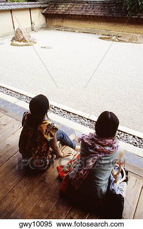High angle view of two young women sitting on wooden planks, Rock garden, Ryoanji temple, Kyoto, Japan View Large Photo Image Stock Photography - High angle view of two young women sitting on wooden planks, Rock garden, Ryoanji temple, Kyoto, Japan. Fotosearch