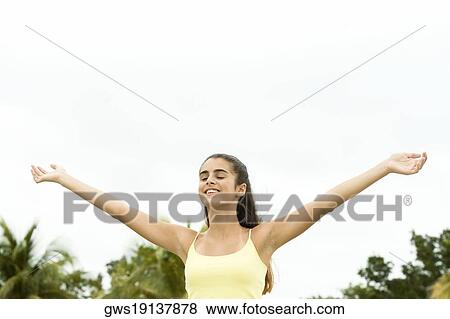 Low angle view of a girl standing with her arms outstretched View Large Photo Image Stock Photo - Low angle view of a girl standing with her arms outstretched. Fotosearch