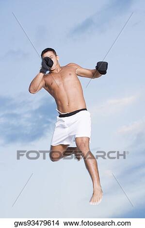 Low angle view of a young man jumping View Large Photo Image Picture - Low angle view of a young man jumping. Fotosearch