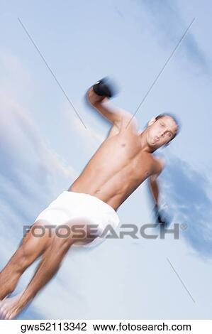 Low angle view of a young man jumping View Large Photo Image Stock Image - Low angle view of a young man jumping. Fotosearch