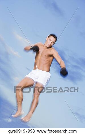Low angle view of a young man jumping View Large Photo Image Stock Photo - Low angle view of a young man jumping. Fotosearch