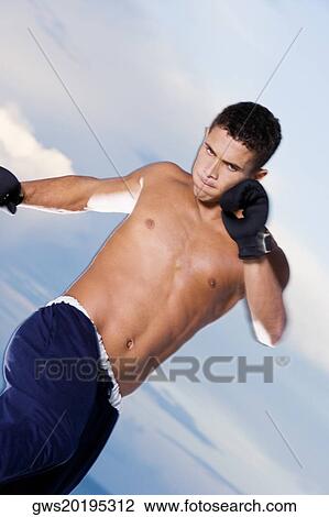 Low angle view of a young man practicing martial arts View Large Photo Image Stock Image - Low angle view of a young man practicing martial arts. Fotosearch