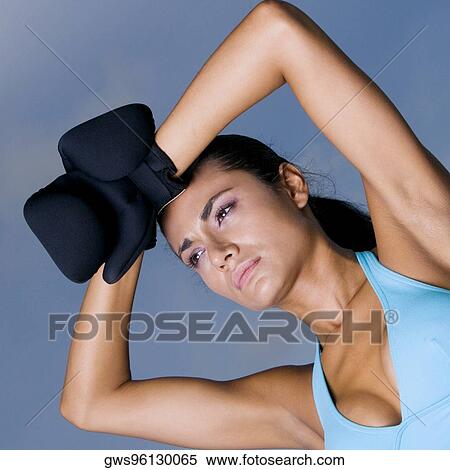 Stock Photography - Low angle view of a young woman wearing boxing gloves. Fotosearch