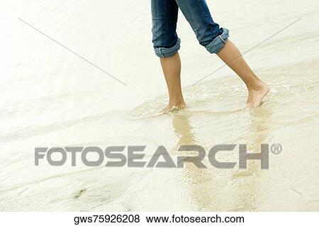 Low section view of a girl wading in water on the beach View Large Photo Image Stock Photo - Low section view of a girl wading in water on the beach. Fotosearch