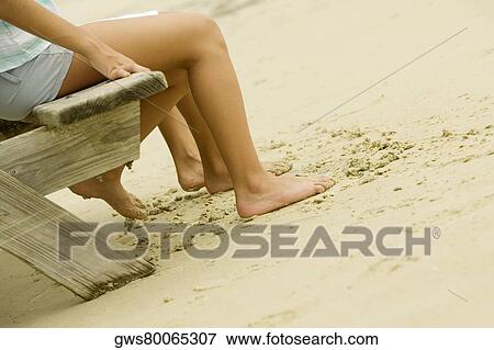 Low section view of a man and a woman sitting on a bench View Large Photo Image Stock Photo - Low section view of a man and a woman sitting on a bench. Fotosearch