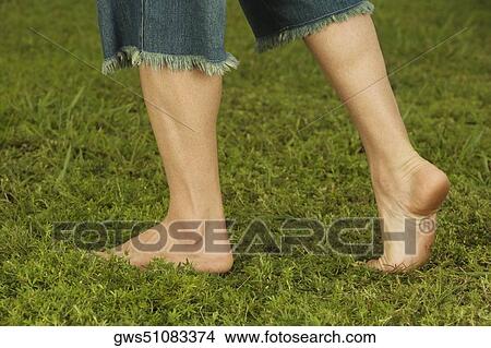 Low section view of a mid adult man walking on the grass View Large Photo Image Picture - Low section view of a mid adult man walking on the grass. Fotosearch