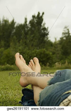 Low section view of a mid adult man lying on the grass View Large Photo Image Stock Image - Low section view of a mid adult man lying on the grass. Fotosearch
