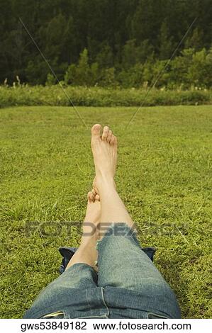 Low section view of a mid adult man lying on the grass View Large Photo Image Stock Image - Low section view of a mid adult man lying on the grass. Fotosearch