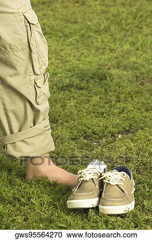Low section view of a mid adult man standing on the grass View Large Photo Image Stock Image - Low section view of a mid adult man standing on the grass. Fotosearch