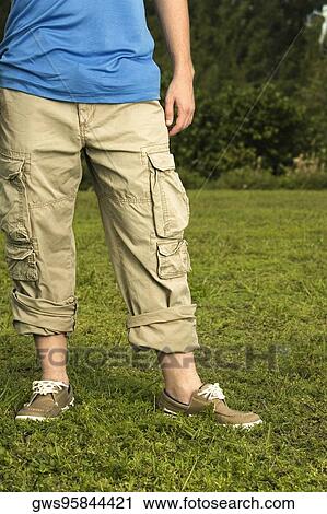 Low section view of a mid adult man standing on the grass View Large Photo Image Stock Image - Low section view of a mid adult man standing on the grass. Fotosearch