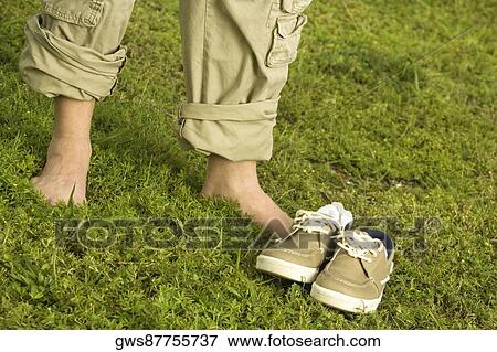 Low section view of a mid adult man standing on the grass View Large Photo Image Stock Photo - Low section view of a mid adult man standing on the grass. Fotosearch