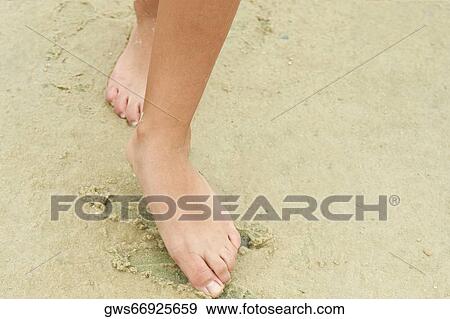 Low section view of a woman drawing in sand with her toe View Large Photo Image Stock Photo - Low section view of a woman drawing in sand with her toe. Fotosearch
