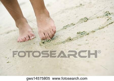 Low section view of a woman drawing in sand with her toe View Large Photo Image Stock Photography - Low section view of a woman drawing in sand with her toe. Fotosearch