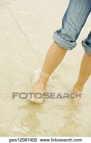 Low section view of a young woman standing on the beach View Large Photo Image Stock Image - Low section view of a young woman standing on the beach. Fotosearch