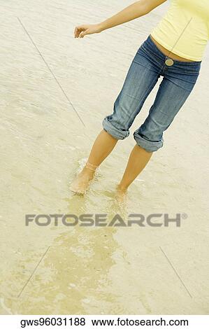 Low section view of a young woman standing on the beach View Large Photo Image Stock Photo - Low section view of a young woman standing on the beach. Fotosearch