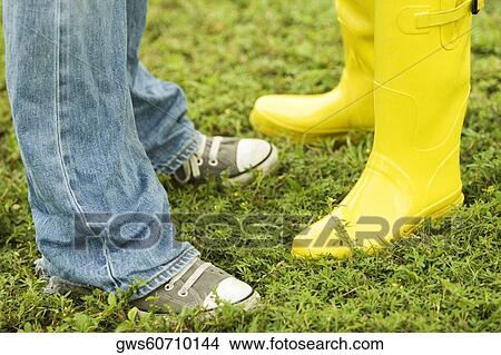 Low section view of two people standing on the grass View Large Photo Image Picture - Low section view of two people standing on the grass. Fotosearch