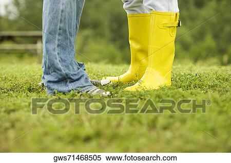 Low section view of two people standing on the grass View Large Photo Image Stock Photography - Low section view of two people standing on the grass. Fotosearch