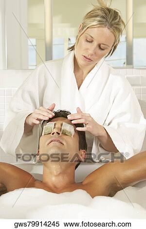 Massage therapist putting teabags on a young man's eyes View Large Photo Image Stock Photography - Massage therapist putting teabags on a young man's eyes. Fotosearch