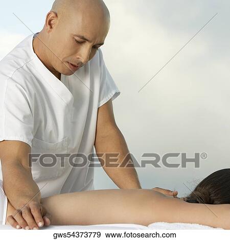Mature man giving a young woman a back massage View Large Photo Image Stock Photo - Mature man giving a young woman a back massage. Fotosearch