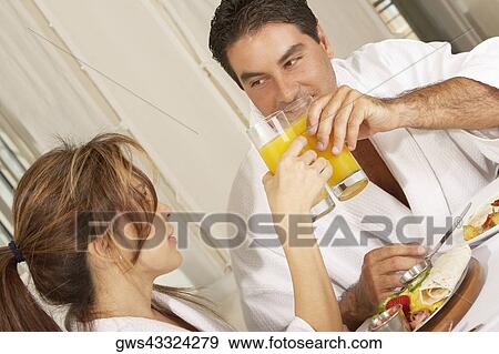 Mid adult couple toasting with glasses of juice View Large Photo Image Stock Photo - Mid adult couple toasting with glasses of juice. Fotosearch