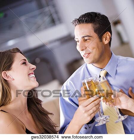 Mid adult man and a young woman raising a toast View Large Photo Image Picture - Mid adult man and a young woman raising a toast. Fotosearch