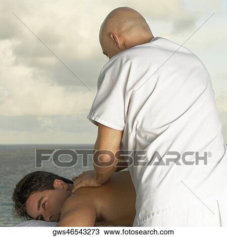 Stock Image - Mid adult man getting a back massage. Fotosearch