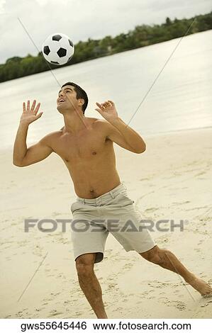 Mid adult man heading a soccer ball on the beach View Large Photo Image Stock Photograph - Mid adult man heading a soccer ball on the beach. Fotosearch