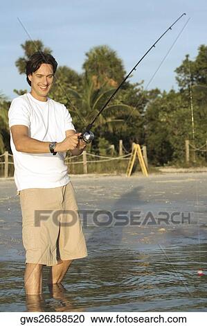 Mid adult man holding a fishing rod View Large Photo Image Stock Image - Mid adult man holding a fishing rod. Fotosearch