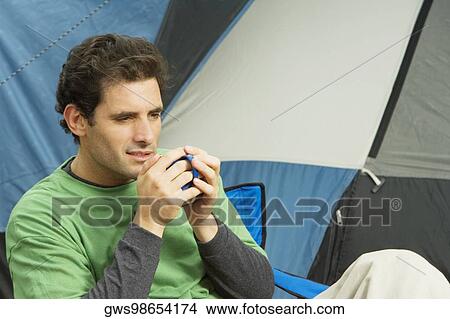 Mid adult man holding a mug View Large Photo Image Picture - Mid adult man holding a mug. Fotosearch