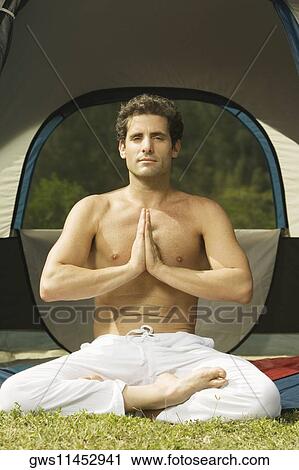 Mid adult man sitting in a prayer position in front of a tent View Large Photo Image Stock Image - Mid adult man sitting in a prayer position in front of a tent. Fotosearch