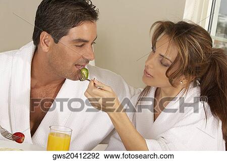 Mid adult woman feeding a mid adult man a slice of cucumber View Large Photo Image Stock Image - Mid adult woman feeding a mid adult man a slice of cucumber. Fotosearch