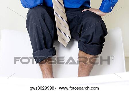 Mid section view of a businessman sitting on a couch View Large Photo Image Stock Photo - Mid section view of a businessman sitting on a couch. Fotosearch