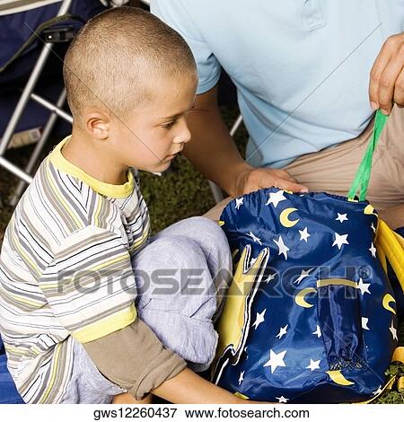 Stock Photo - Mid section view of a father and his son holding a bag. Fotosearch